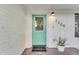 Close-up of a blue-green front door with a welcome mat and a potted plant on a quaint front porch at 2209 N 23Rd St, Phoenix, AZ 85006