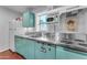 Unique kitchen with vintage turquoise-colored appliances, stainless steel countertops, and quirky retro decor at 2209 N 23Rd St, Phoenix, AZ 85006