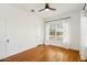 A bright bedroom featuring hardwood floors, large windows with sheer white curtains, and a ceiling fan at 2237 N 9Th St, Phoenix, AZ 85006