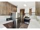 A modern kitchen featuring stainless steel appliances, marbled countertops, and dark wood cabinetry at 2237 N 9Th St, Phoenix, AZ 85006