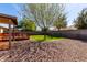 Scenic backyard featuring a deck, rock landscaping, and a mature shade tree at 2251 E Remington Pl, Chandler, AZ 85286