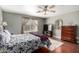 Comfortable bedroom featuring a ceiling fan, wood floors, and a decorative mirror at 2251 E Remington Pl, Chandler, AZ 85286