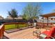 Relaxing outdoor deck with comfortable seating, a wood railing, and lush landscaping at 2251 E Remington Pl, Chandler, AZ 85286