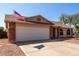 Home exterior featuring a two-car garage, brick accents, desert landscaping, and an American flag at 2251 E Remington Pl, Chandler, AZ 85286