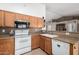 Bright kitchen featuring wood cabinets, white appliances, and laminate countertops for functional cooking space at 2251 E Remington Pl, Chandler, AZ 85286