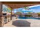 Inviting backyard pool with a pergola covered bar, a stone waterfall feature, and desert landscaping at 2263 E Mariposa Grande --, Phoenix, AZ 85024