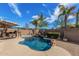 Backyard pool with waterfall feature, palm trees, and an outdoor kitchen at 2263 E Mariposa Grande --, Phoenix, AZ 85024