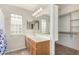 Bathroom featuring a single sink vanity, glass block window, and walk-in closet at 2263 E Mariposa Grande --, Phoenix, AZ 85024