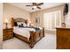 Comfortable bedroom features carpet floors, a ceiling fan, and a wooden bed frame at 23318 N Las Positas Ct, Sun City West, AZ 85375