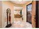 Inviting entryway with tile flooring leads to a dining area with a chandelier and an ornate wrought iron front door at 23318 N Las Positas Ct, Sun City West, AZ 85375