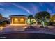 Beautiful single-story home with desert landscaping, illuminated path, and an attached two-car garage at 23318 N Las Positas Ct, Sun City West, AZ 85375