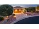 Charming home featuring a two-car garage and meticulously landscaped front yard with warm pathway lighting at 23318 N Las Positas Ct, Sun City West, AZ 85375