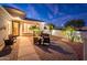 Inviting front courtyard with comfortable seating surrounded by lush landscaping and warm lighting at 23318 N Las Positas Ct, Sun City West, AZ 85375