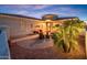 Welcoming front patio adorned with comfortable seating, lush landscaping, and warm lighting at 23318 N Las Positas Ct, Sun City West, AZ 85375