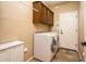 Practical laundry room with front load washer/dryer and storage cabinets at 23318 N Las Positas Ct, Sun City West, AZ 85375