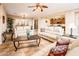 Bright living room with tile floors, white sofas, open to the kitchen and dining areas at 23318 N Las Positas Ct, Sun City West, AZ 85375