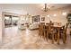 Open-concept living area with tile floors, a ceiling fan, and views of the backyard patio through sliding glass doors at 23318 N Las Positas Ct, Sun City West, AZ 85375