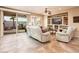 Living room features a comfortable white sofa, entertainment center and sliding door access to a covered patio at 23318 N Las Positas Ct, Sun City West, AZ 85375