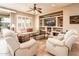 Comfortable living room with white sofas, ceiling fan, and custom shelving surrounding the television at 23318 N Las Positas Ct, Sun City West, AZ 85375