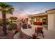 Outdoor living area with comfortable seating, built-in grill, and lush landscaping, perfect for entertaining at 23318 N Las Positas Ct, Sun City West, AZ 85375