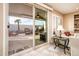 View from inside of the house showing the outdoor patio with furniture and desert landscaping through a large sliding door at 23318 N Las Positas Ct, Sun City West, AZ 85375