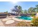 Relaxing pool and spa backyard featuring desert landscaping, rock features, and mature palm trees at 23402 N 22Nd Way, Phoenix, AZ 85024