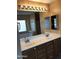 Bathroom featuring dual sinks, granite countertop and tub with window at 25646 W Elwood St, Buckeye, AZ 85326