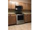 A modern stainless steel range and microwave oven paired with matching wood cabinetry at 25646 W Elwood St, Buckeye, AZ 85326