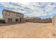 Wide backyard view of a two-story home with a covered patio and desert landscaping at 25792 W Burgess Ln, Buckeye, AZ 85326