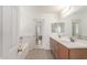 Bathroom featuring double sinks, a large mirror, and a bathtub with tile flooring at 25792 W Burgess Ln, Buckeye, AZ 85326