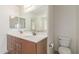 Bathroom featuring double sinks, a large mirror, and a toilet at 25792 W Burgess Ln, Buckeye, AZ 85326