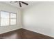 Bedroom features wood-look flooring, a ceiling fan, and a bright window at 25792 W Burgess Ln, Buckeye, AZ 85326