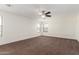 Spacious carpeted bedroom with a ceiling fan and bright natural light from multiple windows at 25792 W Burgess Ln, Buckeye, AZ 85326