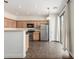 Well-lit kitchen featuring stainless steel appliances, light wood cabinets, and access to the patio at 25792 W Burgess Ln, Buckeye, AZ 85326