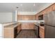 Kitchen featuring stainless steel appliances, light wood cabinets, and ample counter space at 25792 W Burgess Ln, Buckeye, AZ 85326