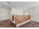 Open loft area with carpet flooring, a wooden railing, and a view of the upper level at 25792 W Burgess Ln, Buckeye, AZ 85326