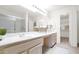 Bright bathroom featuring dual sinks, a large mirror, and a walk-in shower with glass doors at 25822 S Eastlake Dr, Sun Lakes, AZ 85248