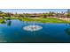 A serene lake featuring a fountain, with the golf course and landscaping in the background at 25822 S Eastlake Dr, Sun Lakes, AZ 85248