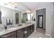 A bathroom features granite counters, dual sinks, and a decorative plant for a touch of nature at 25951 N 106Th Dr, Peoria, AZ 85383