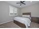 This bedroom features a dark wood queen-size bed, carpeted floors, and a ceiling fan at 25951 N 106Th Dr, Peoria, AZ 85383