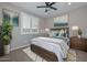 This staged bedroom features a dark wood queen-size bed, carpeted floors, and wall art at 25951 N 106Th Dr, Peoria, AZ 85383