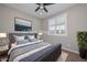 A staged bedroom with carpet floors features a comfortable queen-size bed, and a ceiling fan at 25951 N 106Th Dr, Peoria, AZ 85383