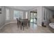 An elegant dining area features a wooden table, natural light, and sliding glass doors to the outdoor patio at 25951 N 106Th Dr, Peoria, AZ 85383