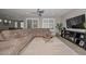 Cozy living room with a large sectional sofa, ceiling fan, and modern entertainment center at 25951 N 106Th Dr, Peoria, AZ 85383