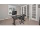 Well-lit home office with a modern desk setup and French doors leading to another room at 25951 N 106Th Dr, Peoria, AZ 85383