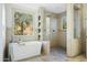 Bright bathroom featuring a modern tub, a glass shower with double shower heads, and scenic outdoor views at 27641 N 74Th St, Scottsdale, AZ 85266