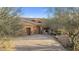 View of a three car garage with desert landscaping. Tiled roof and paver driveway at 27641 N 74Th St, Scottsdale, AZ 85266