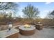 Cozy outdoor fire pit area with built-in seating, landscape lighting, and desert scenery at 27641 N 74Th St, Scottsdale, AZ 85266