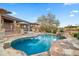 Gorgeous pool with waterfall features, surrounded by stone accents and desert landscape at 27641 N 74Th St, Scottsdale, AZ 85266