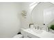 Modern powder room featuring a round mirror, white vanity and stylish faucet at 27641 N 74Th St, Scottsdale, AZ 85266